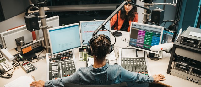 Zwei Frauen sitzen in einem Radio-Studio